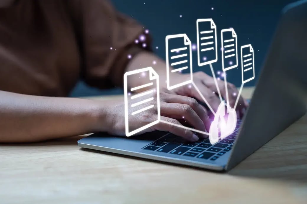 Hands typing on a laptop with digital documents floating above.