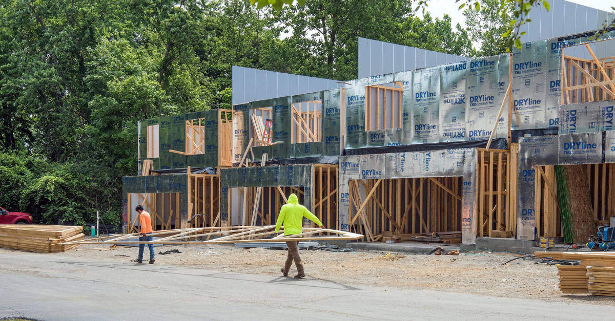 workers installing roof on townhouse development